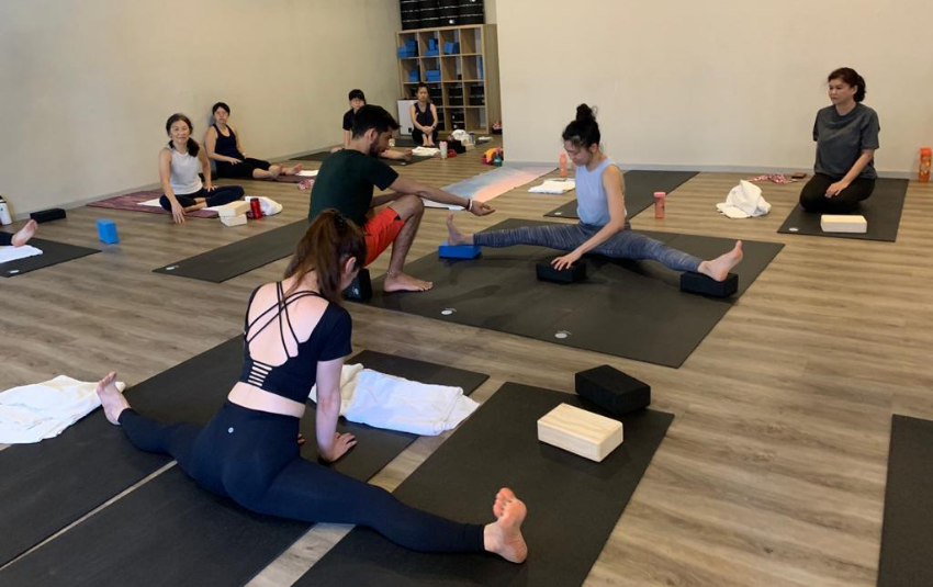 Yoga instructor teaching practioners how to do a split