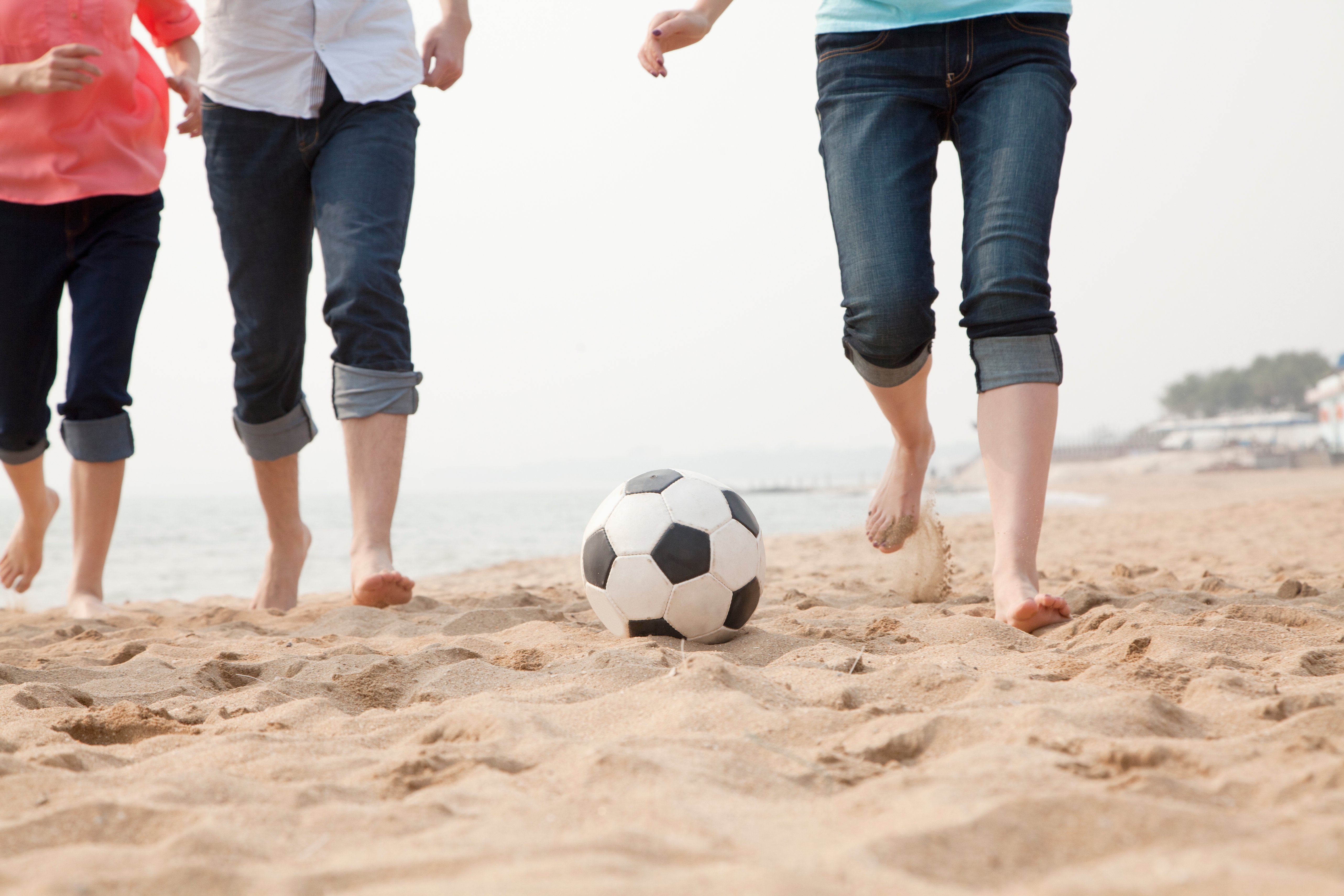 young-friends-playing-soccer-on-the-beach-2021-08-26-15-29-12-utc